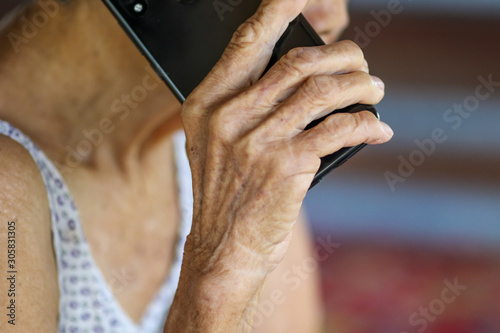 Old woman holding smart phone for shpping online © Golden House Images