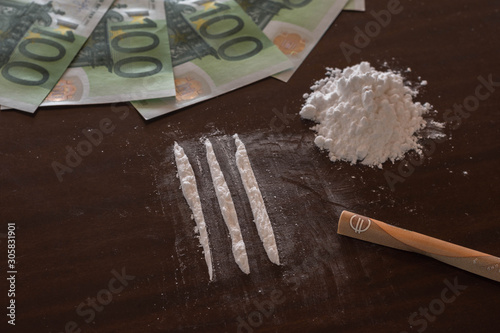 Buying drugs. Table with cocaine euro bank note and rolled euro. Money earned by selling drugs
