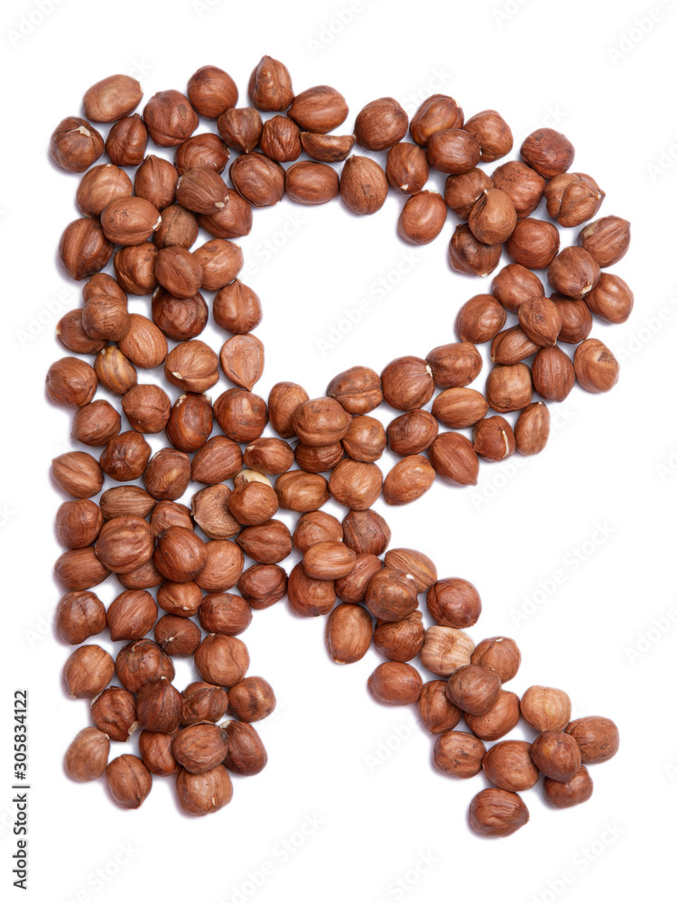 Letter R of the English alphabet from from hazelnut on a white isolated background. Food pattern made from nuts. Bright alphabet for shops. Letter R of the English alphabet from from hazelnut on a white isolated background. Food pattern made from nuts. Bright alphabet for shops.