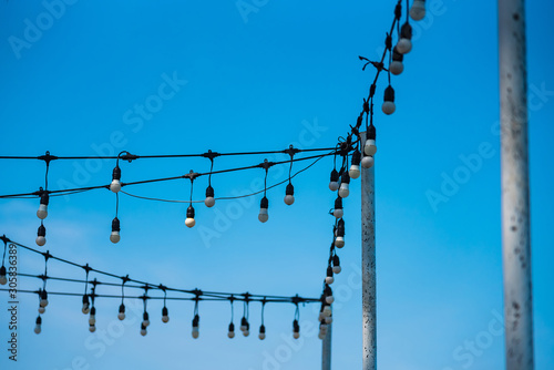 Soft focus light bulbs that decorate during celebrations or festivals on a bright sky background.