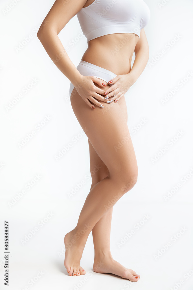 Beautiful female body in underwear isolated on white background. Concept of bodycare and lifting, correction surgery, beauty and perfect skin, weight loss, dieting. Posing confident with hands on hips