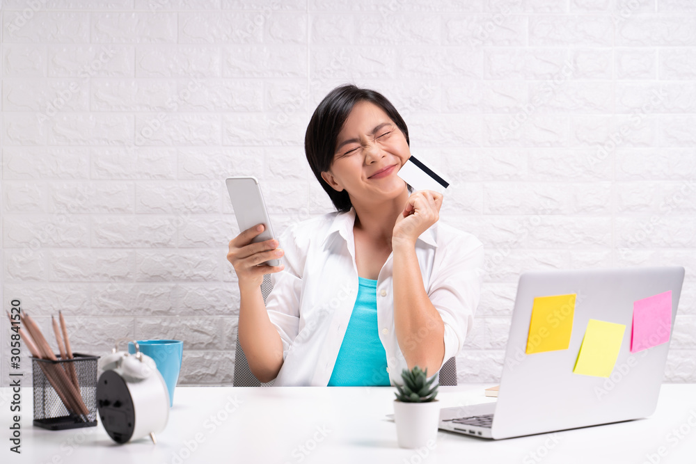 Happy woman use smart phone and credit card at office Happy woman use smart phone and credit card at office