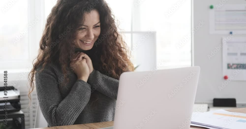 Excited businesswoman celebrating online success using laptop at office Excited businesswoman celebrating online success using laptop at office