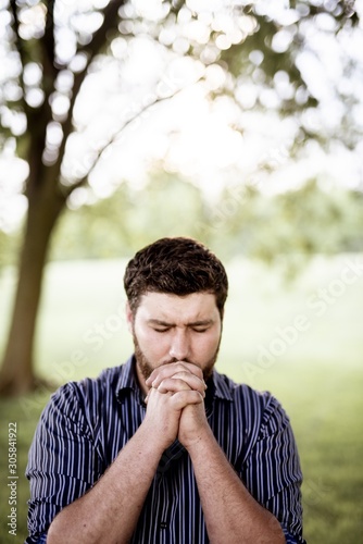 Fotografia Closeup shot of male with his hands near his mouth while praying