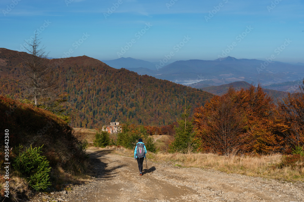 Autumn scenery in the Ukrainian Carpathian Mountains with a tourist girl with a backpack