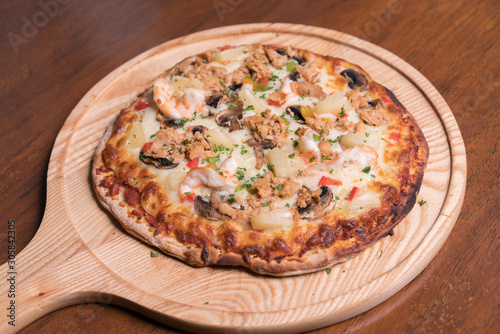 Tuna pizza with shrimp and pineapple, isolated, top view.