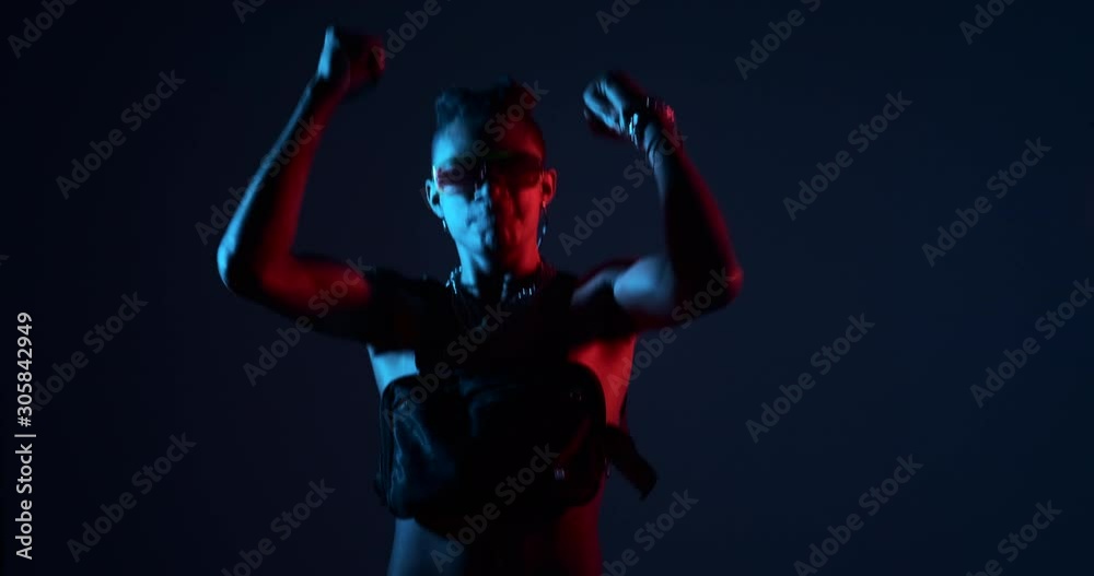 Shirtless man dancing with bag and glowing glasses at rave party Shirtless man dancing with bag and glowing glasses at rave party