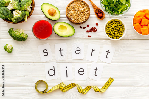 Start diet text near healthy food on white wooden background top view