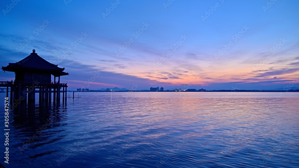日の出直前のピンクに染まる空と浮御堂と琵琶湖の情景