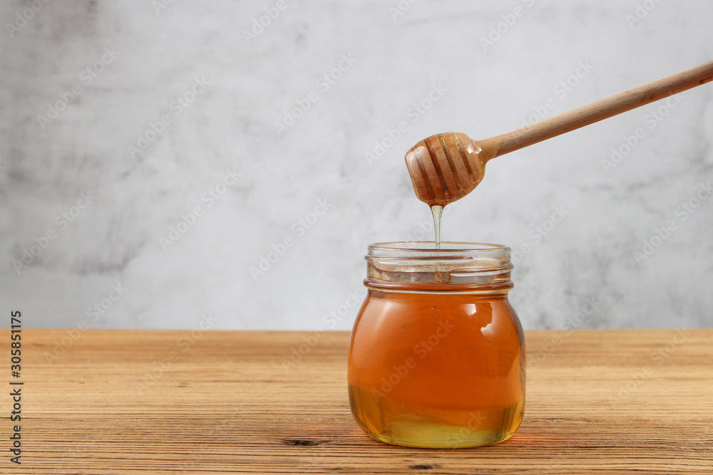 honey in a jar with dipper on wooden background honey in a jar with dipper on wooden background