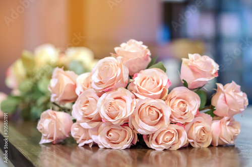 Beautyful bouquet of pink artificial roses placed on the table to decorate the coffee shop.