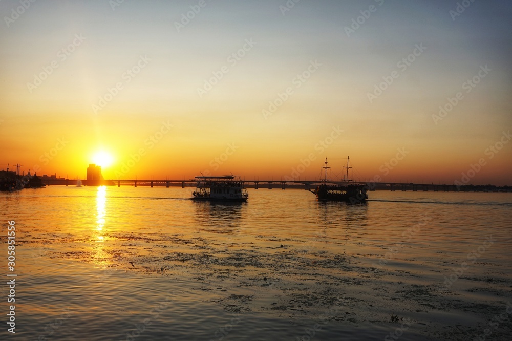 Two ships sail towards each other. Sunset on the Dnieper River.