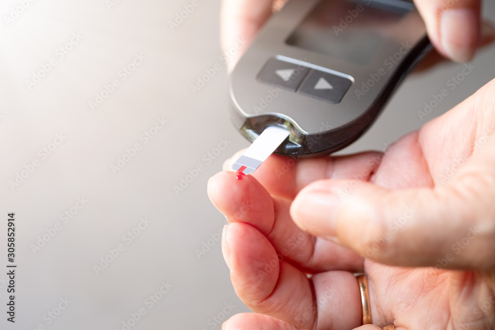 old women checks the amount of sugar in the blood. High blood sugar lever.