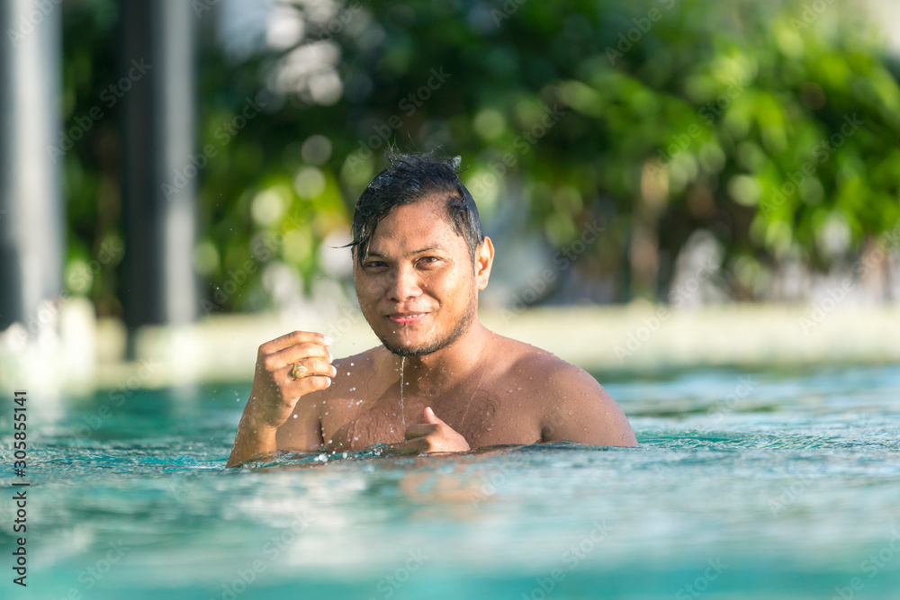 Asian Malay man swimming at the pool