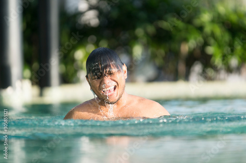 Asian Malay man swimming at the pool