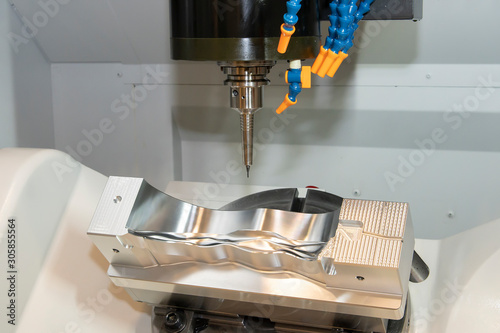 The 5-axis CNC milling machine  cutting the mold and die parts by solid ball endmill tools. The automotive parts manufacturing process by 5-axis machining center. photo