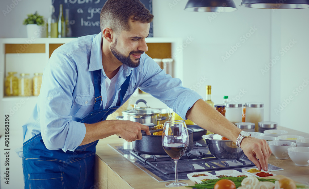 Smiling and confident chef standing in large kitchen Smiling and confident chef standing in large kitchen