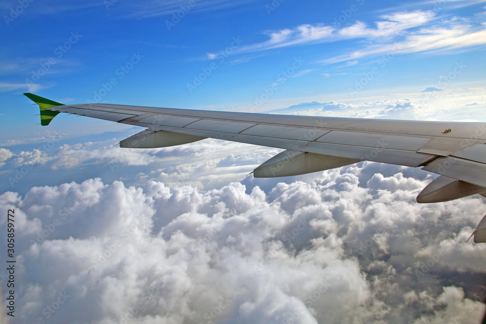 wing of airplane flying above clouds wing of airplane flying above clouds