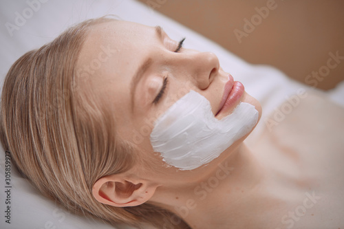 Beautiful young woman in cosmetic salon close up