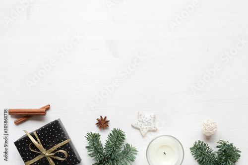 White wood christmas background with gift, christmas decor and white candle, top view. Hygge style