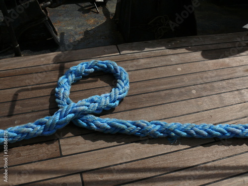 Large ship line resting on the floor of the bridge covered in wood.