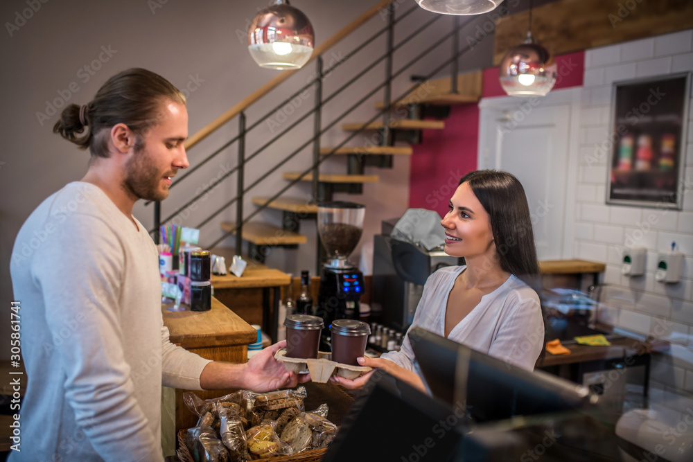 Bearded man getting takeaway coffee in favorite coffee shop Bearded man getting takeaway coffee in favorite coffee shop