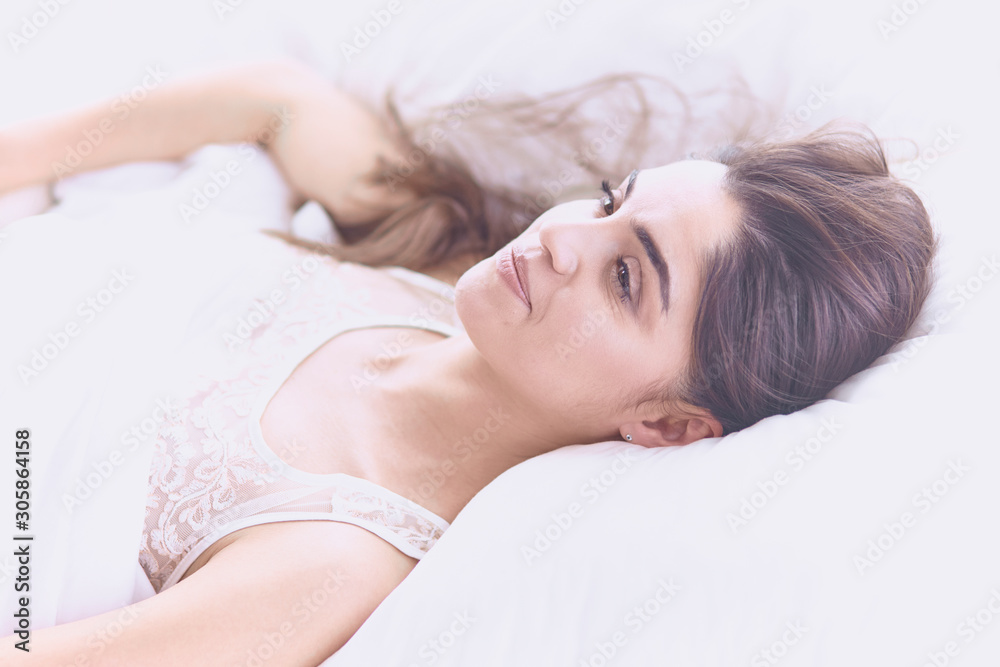 beautiful young woman basking in bed in the morning. Beautiful beautiful young woman basking in bed in the morning. Beautiful