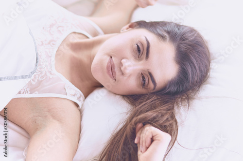 beautiful young woman basking in bed in the morning. Beautiful