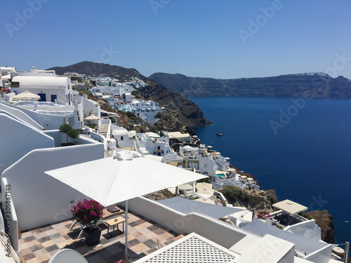 Ancient greek volcanic island from above. Roofs of houses on the mountain against the background of the sea.