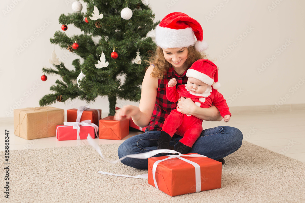 Family, childhood and Christmas concept - Portrait of happy mother and adorable baby in suit of Santa Family, childhood and Christmas concept - Portrait of happy mother and adorable baby in suit of Santa