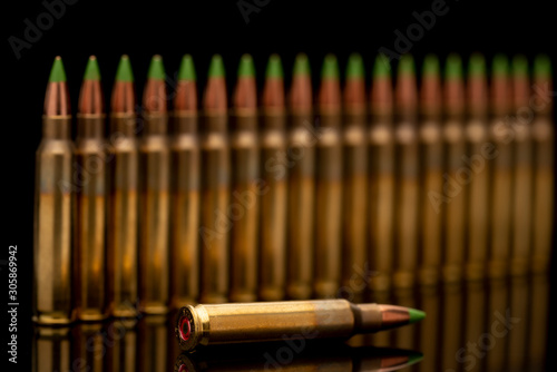 A group of 5.56 calibar, green tip bullets ordered into the line