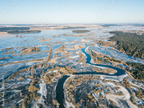 Winter landscape on a winding river in ice. Drone view photo from the drone on a clear day. Aerial top view beautiful snowy landscape.