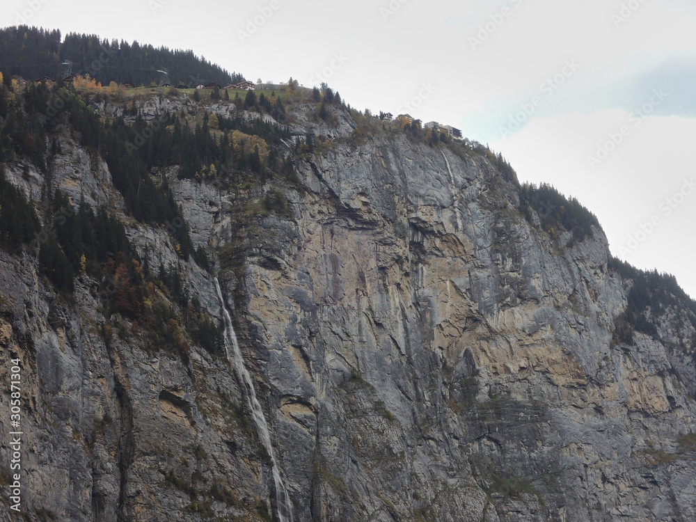 Fototapeta premium The village of Mürren on the waterfall of Mürrenbachfall in the Lauterbrunnen valley. Bernese Oberland. Switzerland