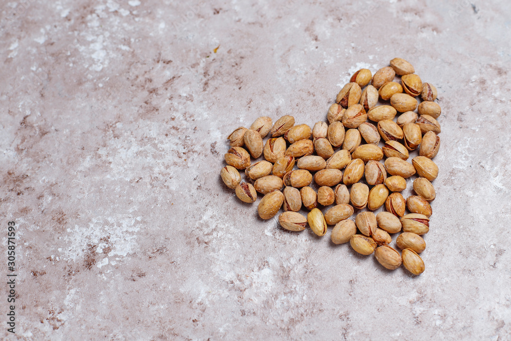 Pistachio nuts in shape of heart on concrete background. Pistachio nuts in shape of heart on concrete background.
