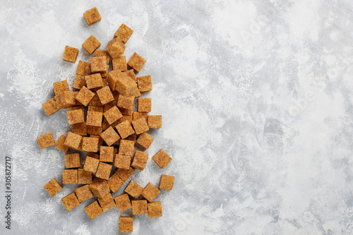 Brown sugar cubes on concrete background,top view