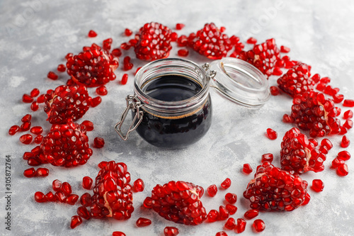 Sweet pomegranate sauce or syrup for meat and fish called narsharab, in a glass jar with purified pomegranate,selective focus photo