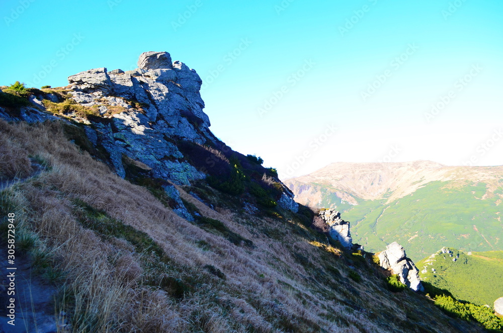 Obraz premium Amazing mountain landscape with colorful vivid sunset on the cloudy sky, natural outdoor travel backgroun