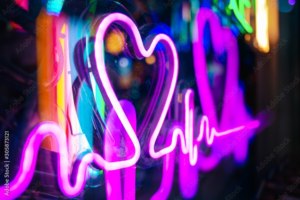 Closeup shot of a glowing purple neon heartbeat sign with a blurred background - obrazy, fototapety, plakaty 