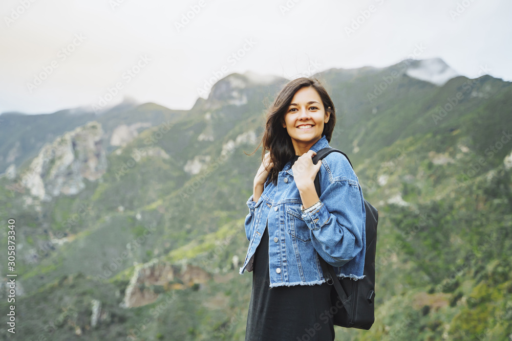Happy smiling woman with backpack on in the mountains. Travel and lifestyle concept