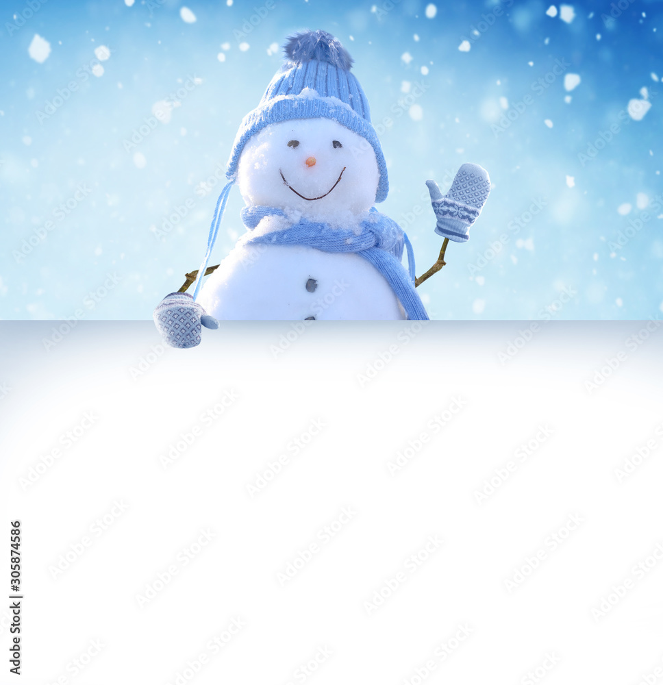 Plakat Wesołych Świąt i szczęśliwego nowego roku kartkę z życzeniami. Snowman stojący w zimowym krajobrazie Bożego Narodzenia i wskazuje na biały billboard.