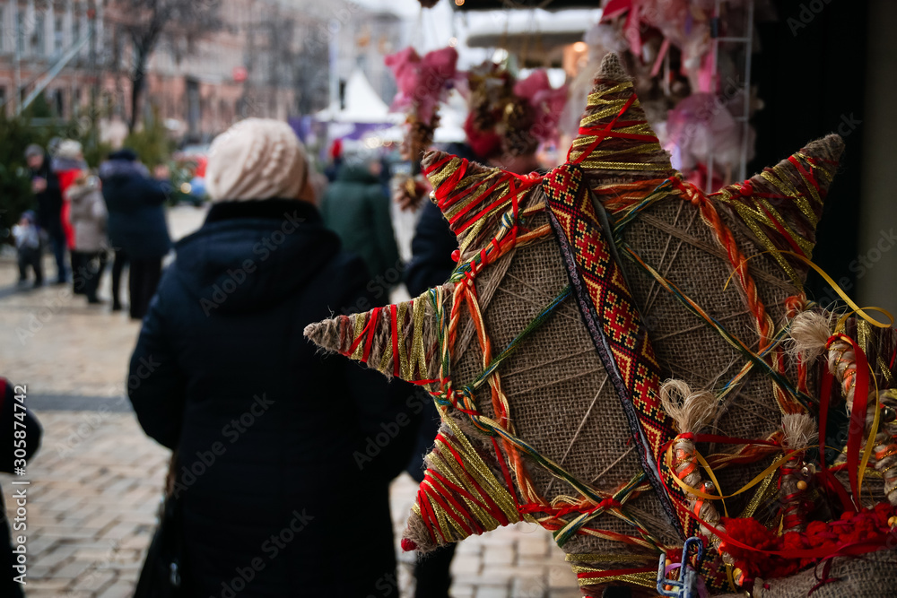 Christmas craft star with color decoration. Street festive fair. Anticipation of gifts and happiness.