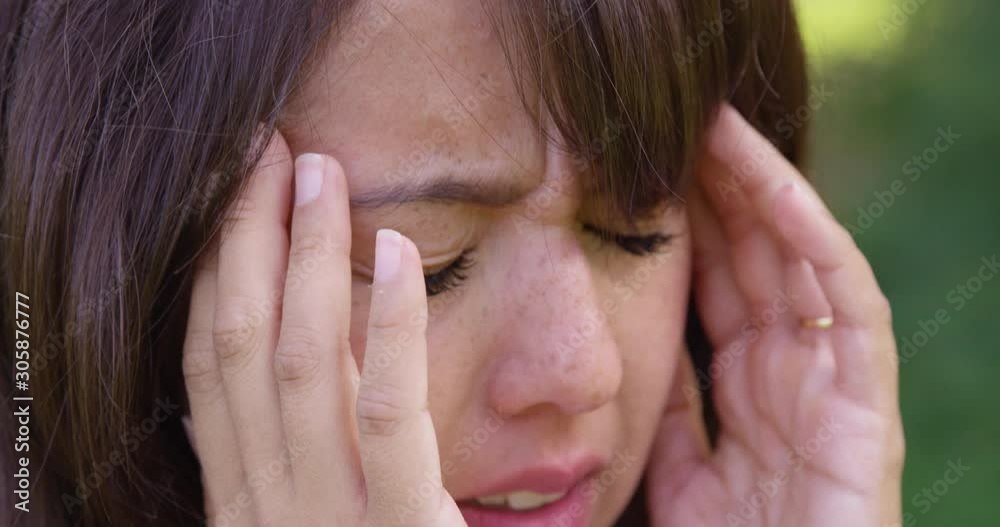 A young woman reacts to a migraine headache outside - shot on RED A young woman reacts to a migraine headache outside - shot on RED