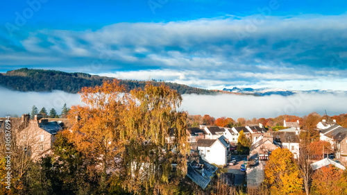 Aerial top view over Bowness On Windermere on an early morning with fog and mist rising on lake Windermere. Autumn in the Lake District, Cumbria, UK.  photo