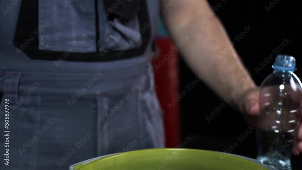 Man pouring water from the bottle to yellow bucket.