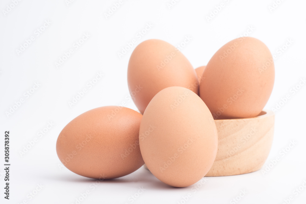 Organic fresh chicken eggs in a brown wooden bowl on a white background Organic fresh chicken eggs in a brown wooden bowl on a white background