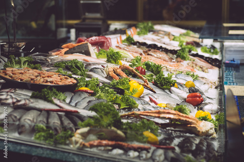 Fresh fish and seafood in a fish market window display. Variety and types of oceanic seafood for sale in a restaurant
