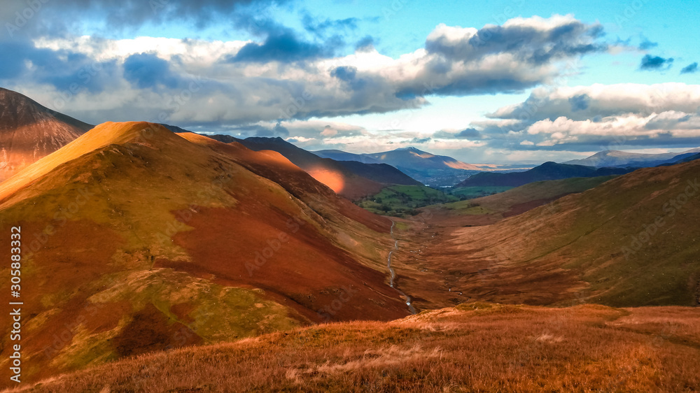 Obraz premium Scenic valley in autumn with snow capped mountain peaks. Touristic destination in the Lake District, Cumbria, United Kingdom. Top aerial view of peaks.