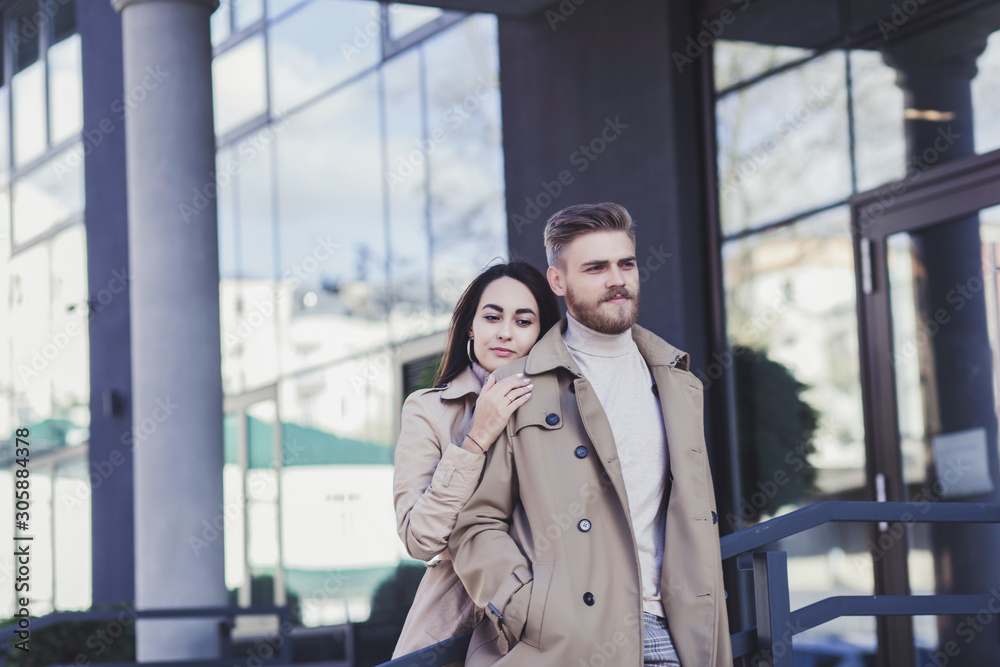 calm young couple standing arm in arm in coat outdoors calm young couple standing arm in arm in coat outdoors