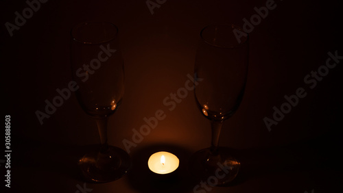 Burning candle near the glasses of champagne, romantic dinner