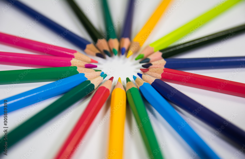 Closup view of set of color pencils in a floral flower circular shape circle pencils in focus on white background